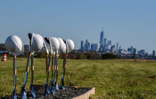 Hard hats on shovels with Manhattan skyline in the distance